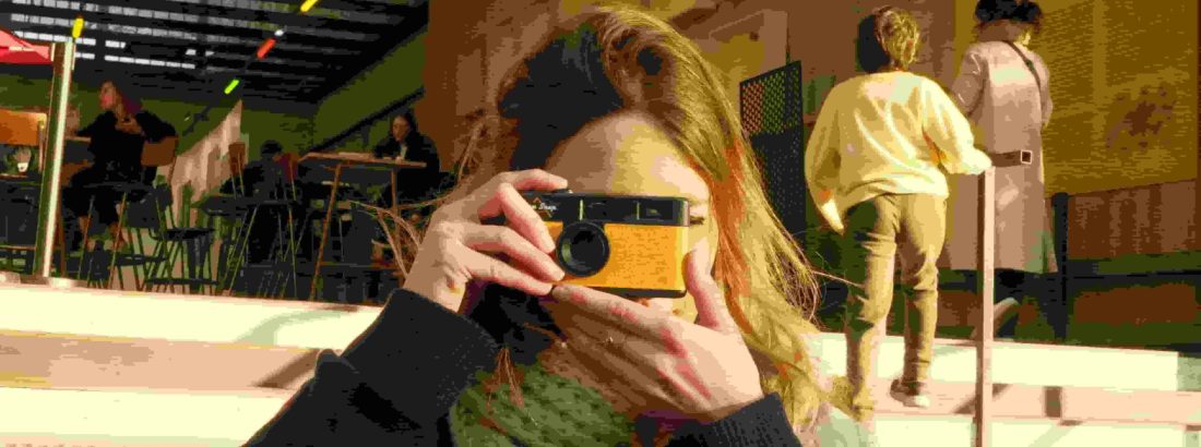 A girl holding a camera represents the blog of the best digital marketer in Kasaragod